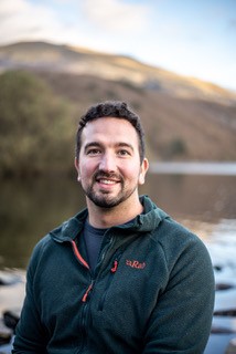 Headshot photograph of speaker Darren Edwards against mountain background